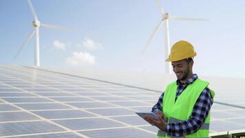 giovane ingegnere Guardando su digitale tavoletta il nuovo verde Piano per alternativa energia con vento turbina e solare pannello - innovazione e verde energia concetto video