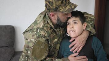 Military soldier kissing his son with disability at home video