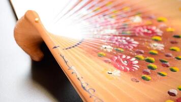 Hand fan in wood decorated with flower gyrating video