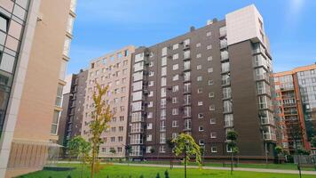 A modern multi-storey brick residential complex with a private landscape. Newly built multi-storey residential complex in a residential area with landscaping around the house. video