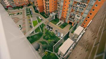 A top view of the modern territory of the residential complex, an interesting angle from above to the courtyard of new buildings. Parked cars, landscaping of the surrounding area in a new multi-storey video