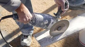 un hombre es utilizando un amoladora a cortar un pedazo de hormigón video