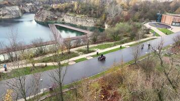 motociclistas equitação passado zakrzowek lago, motociclistas em uma estrada viagem passagem de a sereno águas do zakrzowek lago durante outono dentro Cracóvia, Polônia. video