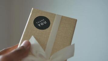 holding a gift box with thank you sticker on it video