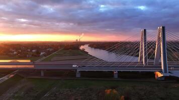 aéreo ver puesta de sol terminado moderno puente en cracovia, el Dom ajuste detrás un moderno atirantado puente en cracovia, fundición un dorado resplandor terminado el estructura y la carretera. video