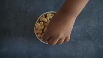 top view of child hand picks cashew nuts video