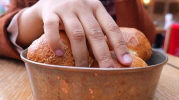 women hand pick baked bun on table video