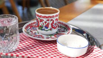 un taza de turco café, vaso de agua y deleite en un mesa video