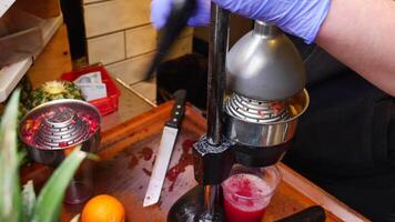 squeezing oranges into orange juice at cafe. video