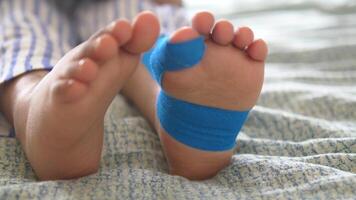 Elastic therapeutic blue tape applied to child leg. Kinesio Taping therapy for injury video