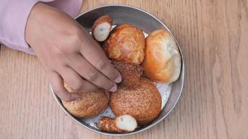 women hand pick baked bun on table video