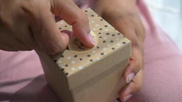 hand putting a thank you sticker on a gift box video