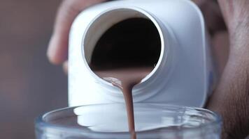 pouring chocolate milk from a container close up video