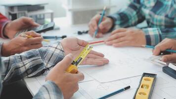 architector en ingenieurs met droogte plan van gebouw en tablet pratend Aan construeren plaats. bouw manager en ingenieur werken Aan gebouw plaats. video