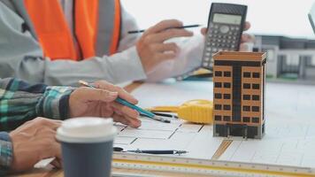 Architector and engineers with draft plan of building and tablet talking on constructing site. Construction manager and engineer working on building site. video