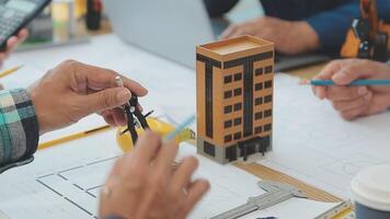 architetto e ingegneri con bozza Piano di edificio e tavoletta parlando su costruzione luogo. costruzione manager e ingegnere Lavorando su edificio luogo. video