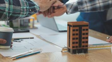 arquitecto y ingenieros con sequía plan de edificio y tableta hablando en construyendo sitio. construcción gerente y ingeniero trabajando en edificio sitio. video