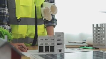 Architector and engineers with draft plan of building and tablet talking on constructing site. Construction manager and engineer working on building site. video