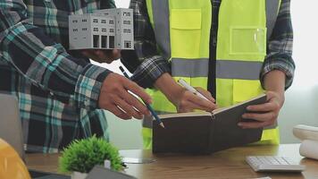 Architector and engineers with draft plan of building and tablet talking on constructing site. Construction manager and engineer working on building site. video