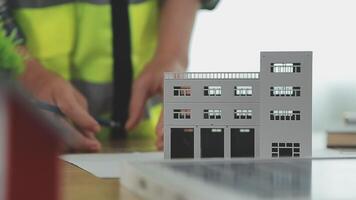 architector en ingenieurs met droogte plan van gebouw en tablet pratend Aan construeren plaats. bouw manager en ingenieur werken Aan gebouw plaats. video