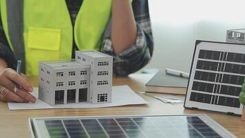 architetto e ingegneri con bozza Piano di edificio e tavoletta parlando su costruzione luogo. costruzione manager e ingegnere Lavorando su edificio luogo. video