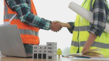 Architector and engineers with draft plan of building and tablet talking on constructing site. Construction manager and engineer working on building site. video