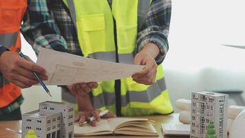 Architector and engineers with draft plan of building and tablet talking on constructing site. Construction manager and engineer working on building site. video