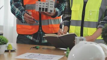 arquitecto y ingenieros con sequía plan de edificio y tableta hablando en construyendo sitio. construcción gerente y ingeniero trabajando en edificio sitio. video