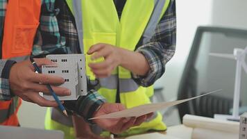 arquitecto y ingenieros con sequía plan de edificio y tableta hablando en construyendo sitio. construcción gerente y ingeniero trabajando en edificio sitio. video