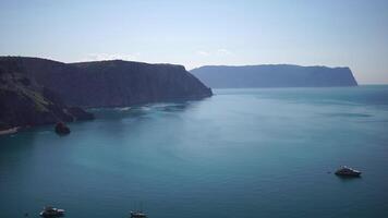 Aerial view from above on calm azure sea and volcanic rocky shores. Small waves on water surface in motion blur. Nature summer ocean sea beach background. Nobody. Holiday, vacation and travel concept video