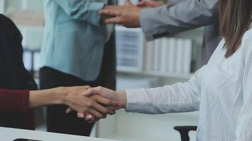 Young business people shaking hands in the office. Finishing successful meeting. Three persons. Wide screen panoramic video