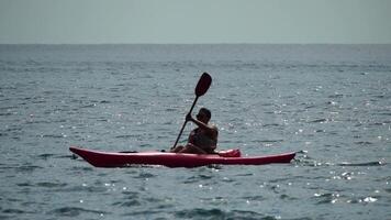 hav kvinna kajak. Lycklig kvinna i liv jacka paddling de kajak på hav. kvinna är njuter henne sommar semester på strand. kvinna utforska lugna hav förbi kanot på Semester semester helgen. video