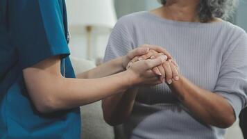 emotioneel comfort opgeslagen in vingerafdrukken. schot van een onherkenbaar dokter Holding handen met haar geduldig gedurende een overleg. video