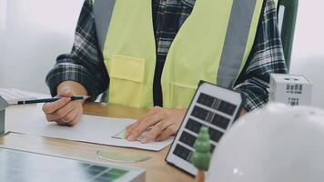 arquitecto y ingenieros con sequía plan de edificio y tableta hablando en construyendo sitio. construcción gerente y ingeniero trabajando en edificio sitio. video