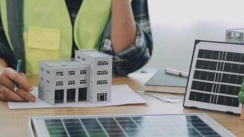 architetto e ingegneri con bozza Piano di edificio e tavoletta parlando su costruzione luogo. costruzione manager e ingegnere Lavorando su edificio luogo. video