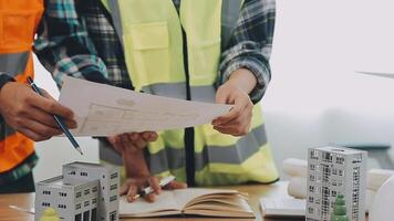 Architector and engineers with draft plan of building and tablet talking on constructing site. Construction manager and engineer working on building site. video