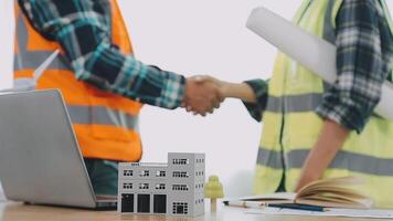 Architector and engineers with draft plan of building and tablet talking on constructing site. Construction manager and engineer working on building site. video