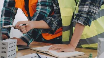 architecte et ingénieurs avec Brouillon plan de bâtiment et tablette parlant sur construire placer. construction directeur et ingénieur travail sur bâtiment placer. video