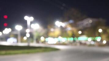 desenfocado coche luces en un noche ciudad calle. abstracción. borroso antecedentes. multicolor círculos de ligero. lento movimiento fuera de atención noche calle puntos de vista de el ciudad carreteras. video