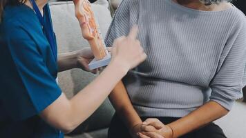 proche en haut médecin, asiatique médecin parler avec vieux femelle patient à propos maladie symptôme, médecin utilisation stéthoscope écoute poumon de patient, personnes âgées santé vérifier en haut, bonheur hôpital video