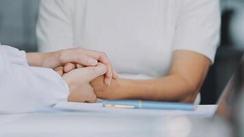 emocional conforto armazenado dentro impressões digitais. tiro do a irreconhecível médico segurando mãos com dela paciente durante uma consulta. video