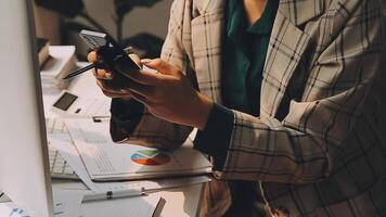 Asian businesswoman in formal suit in office happy and cheerful during using smartphone and working video