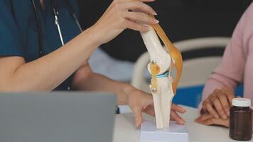 Human cruciate ligament injury treatment concept. Orthopedist showing to cruciate ligament in a knee-joint medical teaching model, close-up video