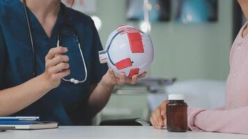 proche en haut de asiatique femelle médecin portant visage masque est montrant globe oculaire modèle et expliquant à propos yeux maladie à aîné Sénior homme patient dans hôpital video