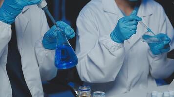 Young scientists conducting research investigations in a medical laboratory, a researcher in the foreground is using a microscope video