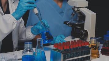 Young scientists conducting research investigations in a medical laboratory, a researcher in the foreground is using a microscope video