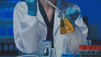 Young scientists conducting research investigations in a medical laboratory, a researcher in the foreground is using a microscope video