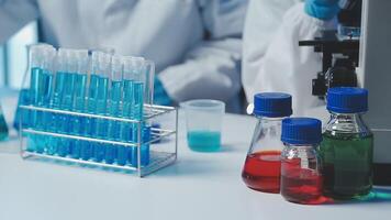 Young scientists conducting research investigations in a medical laboratory, a researcher in the foreground is using a microscope video