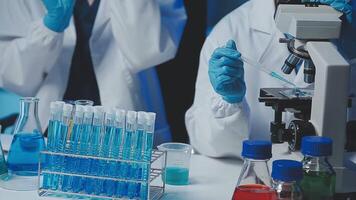 Young scientists conducting research investigations in a medical laboratory, a researcher in the foreground is using a microscope video