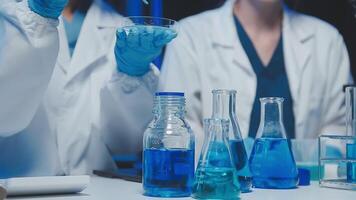 Young scientists conducting research investigations in a medical laboratory, a researcher in the foreground is using a microscope video